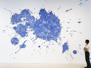 Konstverket 2,4-D. Stort blått konstverk med en person framför.